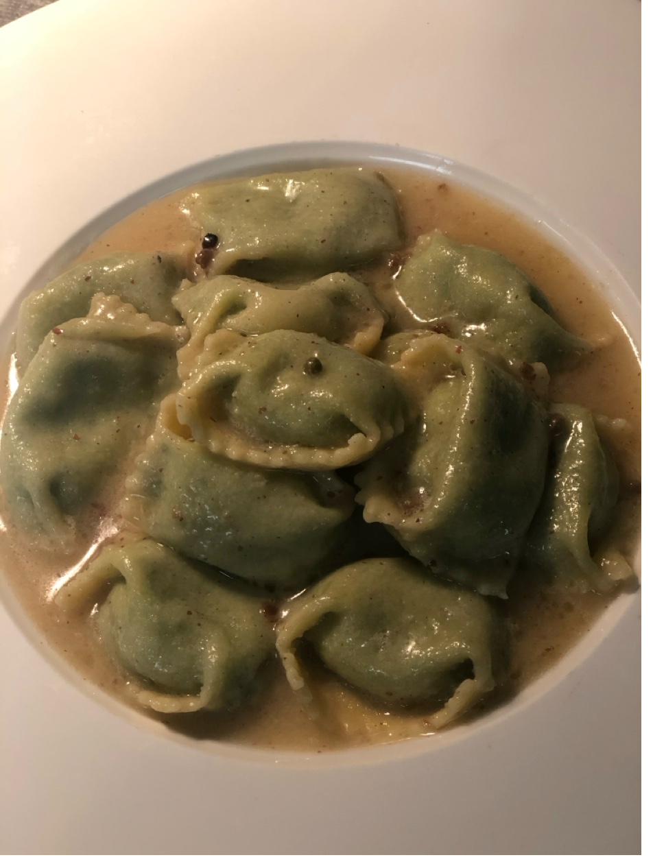 Handmade spinach agnolotti pasta in brown butter cream sauce
