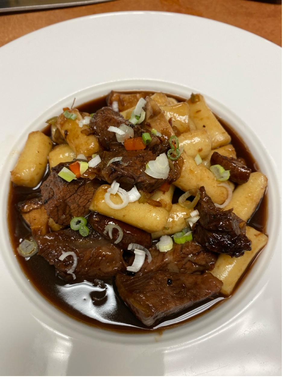 Braised beef short rib with handmade potato gnocchi in rich wine sauce topped with green onions