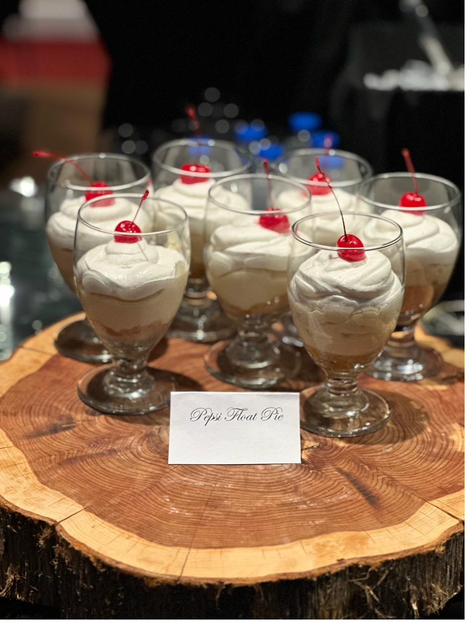 Individual Pepsi Float Pie desserts in parfait glasses topped with whipped cream and cherries